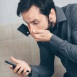 Hardeman County Clerk Warns of Phone Scam Seeking Fees Worried man holding a smartphone and credit card, illustrating the Hardeman County phone scam warning