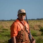 Free Hunter Education Class Set at Lone Oaks Farm in Middleton Hunter wearing blaze orange safety gear in an open field, illustrating a hunter education class