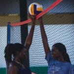 Ripley Volleyball Wins Region 3-4A Title for Second Year Two players compete at the net during an indoor high school volleyball match, illustrating Ripley volleyball's region title
