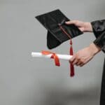 Tippah County Ole Miss Graduates Earn August 2026 Degrees Graduate holding a cap and a diploma tied with a red ribbon, illustrating Tippah County Ole Miss graduates