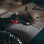 The 5 Best Cordless Tool Sets for Tippah County Home Projects A cordless drill-driver with a drill bit resting on a wooden workbench in a home workshop