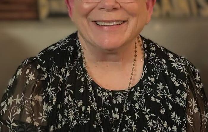 Portrait of BMCU dorm mother Sandra Clark smiling in a black floral blouse