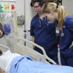 BMCU Nursing Students Face Simulated Emergency in Blue Mountain BMCU nursing students in navy scrubs assess a patient mannequin during a simulated emergency in Blue Mountain