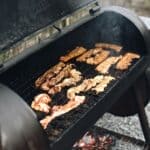 Bolivar BBQ Blowout & Music Festival Set for Oct. 23-24 Meat smoking on an outdoor barbecue grill, illustrating the Bolivar BBQ Blowout festival