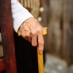 Bolivar Launches Dementia Safety Registration Program Older adult's hand resting on a wooden cane, illustrating Bolivar's dementia safety registration program