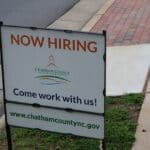 Hardeman County Unemployment Ranks 4th Highest in Tennessee Now Hiring sign in a store window, illustrating Hardeman County unemployment