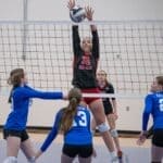 Middleton Volleyball Sweeps Hillcrest in Regional Opener High school girls volleyball players in action at the net, illustrating Middleton volleyball's regional win