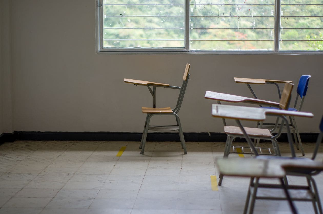 Empty classroom with school desks by a large window, illustrating 2026 school grades