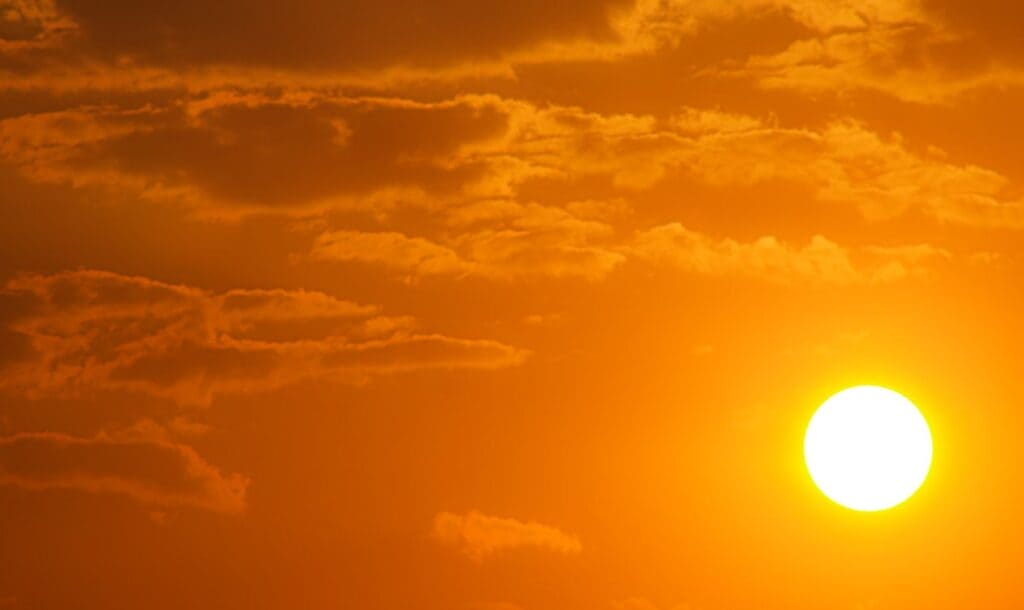 Bright sun in an orange sky illustrating Tippah County heat forecast
