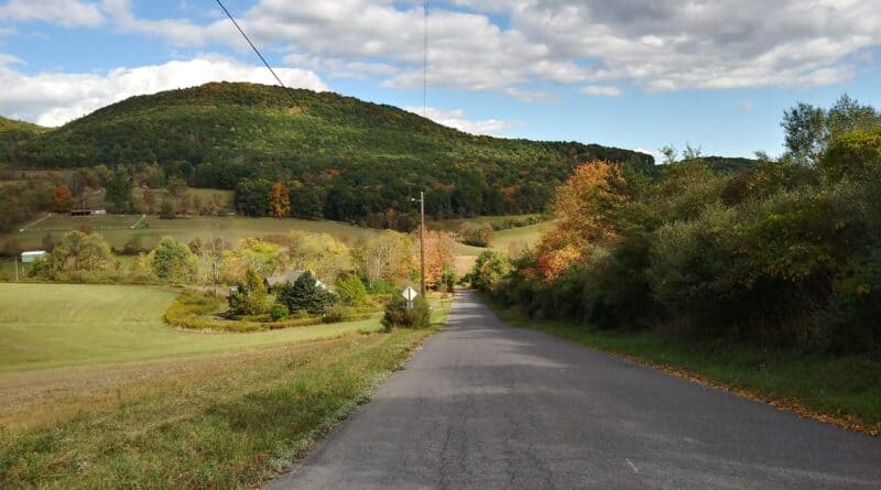 Rural road through early autumn countryside under a partly cloudy sky, representing Tippah County weather